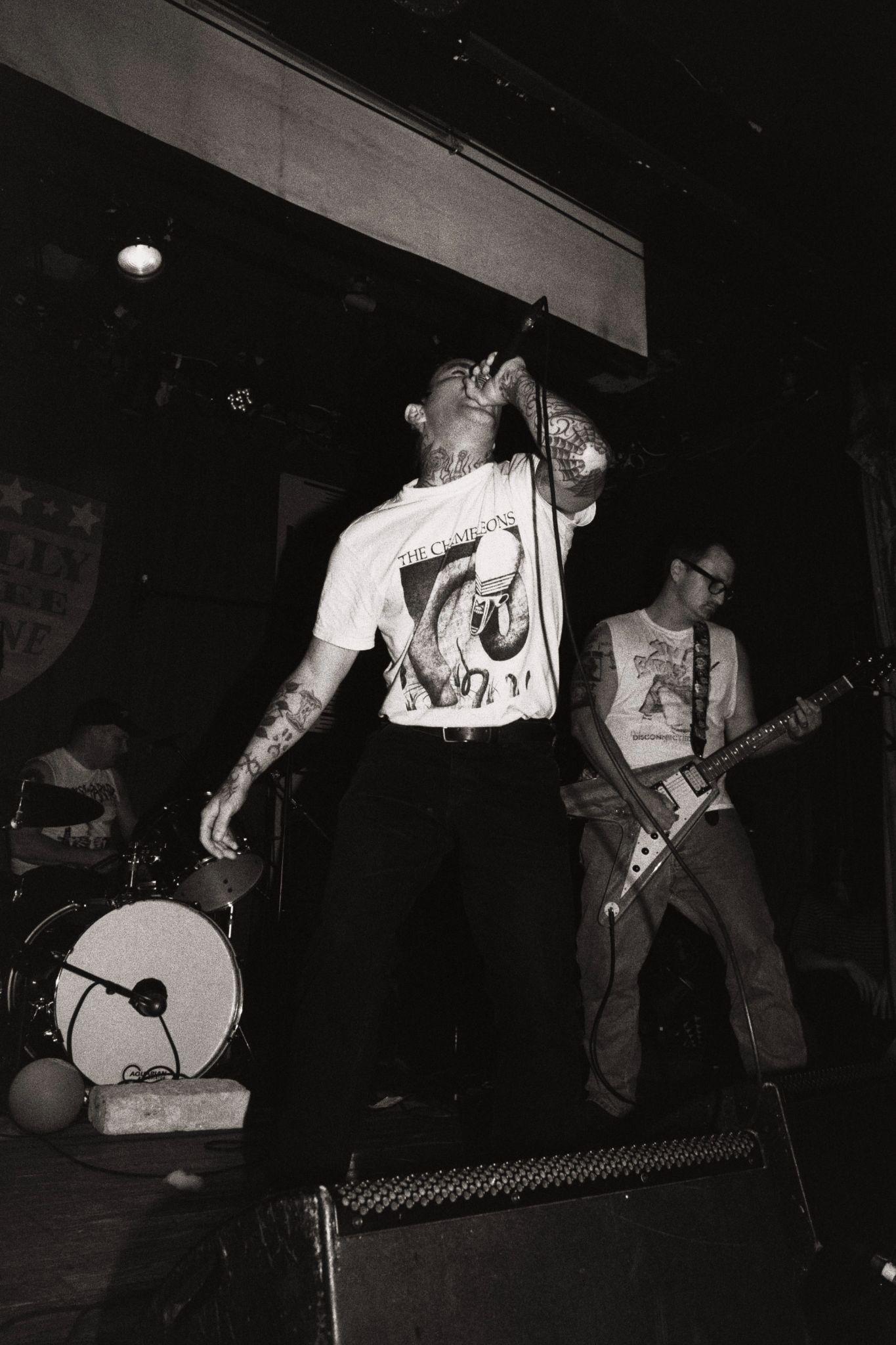 A vocalist and guitarist perform onstage at La Sala Rossa